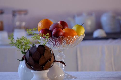- un bol de fruits sur une table avec un ananas dans l'établissement Le Pavillon de l'Orangerie, à Meursanges
