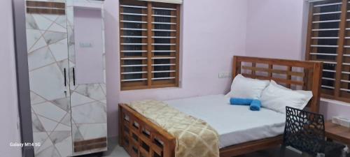 a small bedroom with a bed and a shower at Bluebell Shores -Cozy Stay Near Varkala Beach in Varkala
