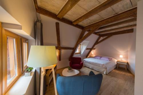 a bedroom with a bed and a lamp and a chair at La Maison d'Emilie in Pfaffenheim