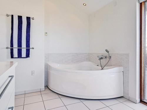 a white bath tub in a white bathroom at 8 person holiday home in Hjørring in Hjørring