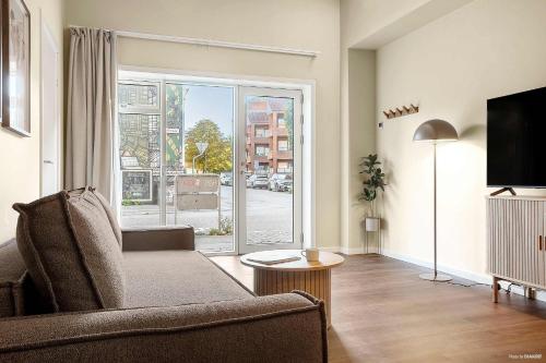 a living room with a couch and a large window at Stylish Easy-Access Ground Floor Apartment for 4 in Aarhus