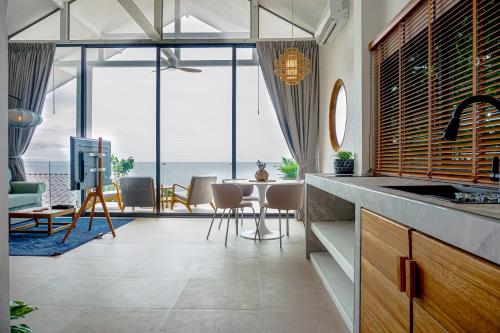 a kitchen with a dining room with a view of the ocean at Serenity Bay Panoramic Sea View in Haad Yao