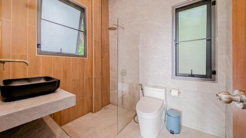 a bathroom with a toilet and a glass shower at Serenity Bay Panoramic Sea View in Haad Yao
