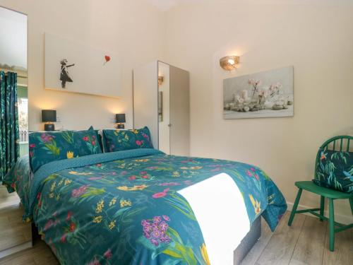 a bedroom with a bed with a blue comforter at Bottom Lodge in Chepstow