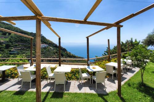 a patio with tables and chairs and a view of the ocean at Fico D'India Relais in Furore