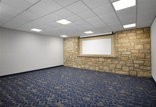 an empty room with a stone wall and a whiteboard at The Oread Lawrence, Tapestry Collection by Hilton in Lawrence