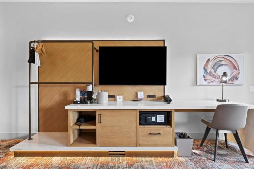 an office with a desk with a tv on it at Hotel De Novo Springdale, Tapestry Collection by Hilton in Springdale