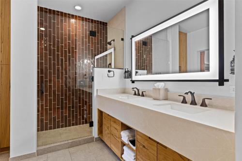 a bathroom with two sinks and a shower at Hotel De Novo Springdale, Tapestry Collection by Hilton in Springdale
