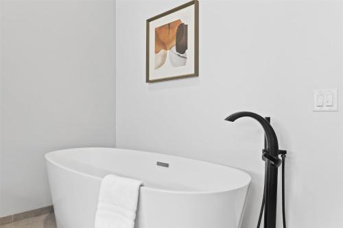 a bathroom with a white tub and a black faucet at Hotel De Novo Springdale, Tapestry Collection by Hilton in Springdale