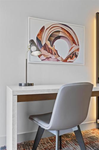 a desk with a chair and a picture on the wall at Hotel De Novo Springdale, Tapestry Collection by Hilton in Springdale