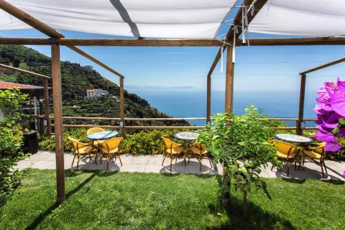 a patio with tables and chairs and a view of the ocean at Fico D'India Relais in Furore
