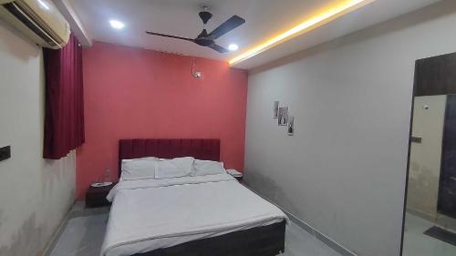 a bedroom with a bed with a red wall at HOTEL O SKY in Phundardih