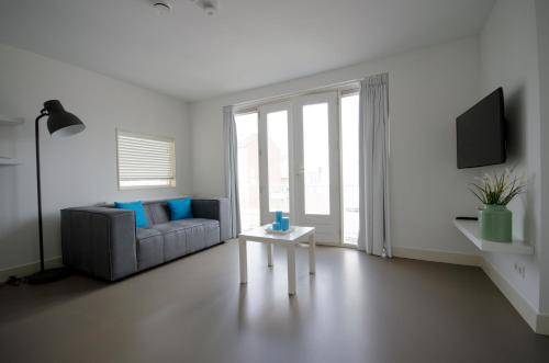 a living room with a couch and a table at Flamingo Beach Apartments in Zandvoort