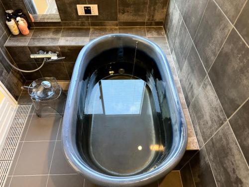a large metal tub in a bathroom with a mirror at Mulan Stay 松尾大社 in Kyoto