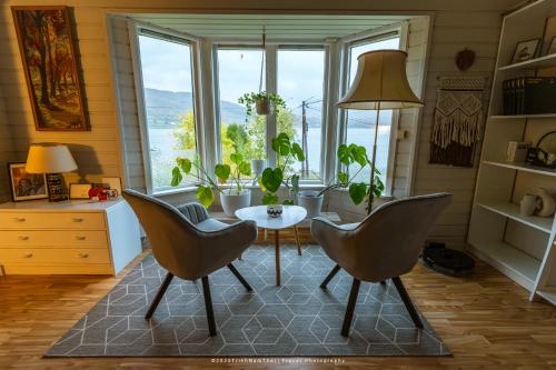 Una habitación con una mesa y sillas y una ventana. en Room at House of ade, en Senja