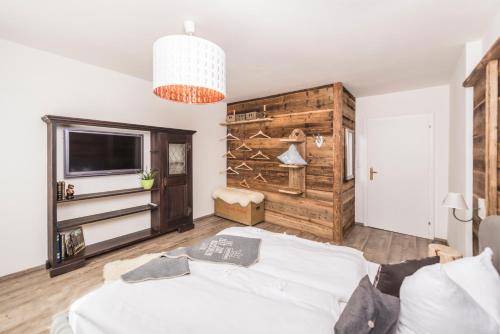 a bedroom with a bed and a wall with a tv at Apartchalet Almliebe in Maria Alm am Steinernen Meer