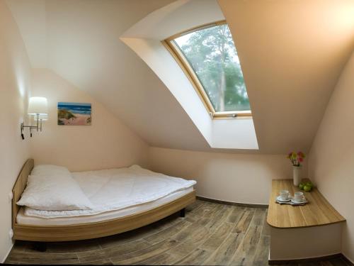 a bedroom with a bed and a window at Leśna7 in Sztutowo