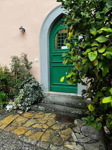 a green door on a house with a stone walkway at Il Casale Di Villa Rossi in Lucca