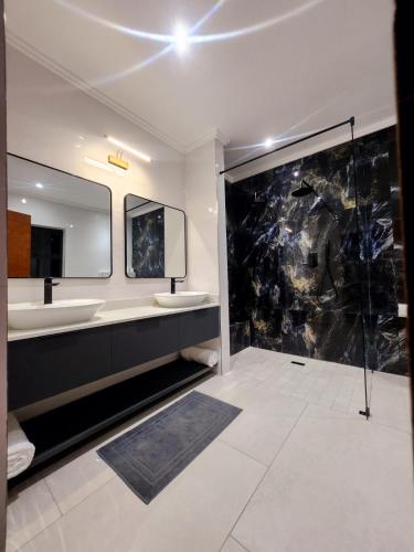 a bathroom with two sinks and a large mirror at Euphoria 447 in Naboomspruit