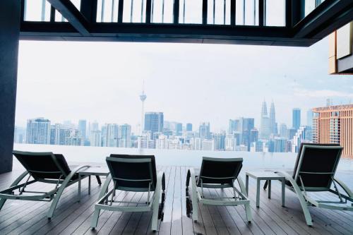 a group of chairs and a table on a balcony at Lucentia Residence Bukit Bintang By Panorama in Bukit Bintang