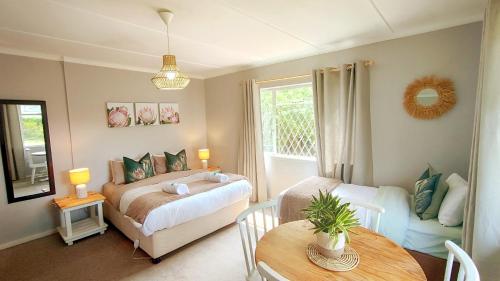 a bedroom with a bed and a table in a room at Willowlea Cottage in Underberg