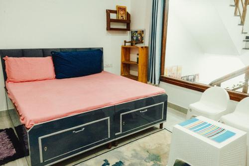 a small bedroom with a black bed with a pink mattress at JM Luxury Homestays in Jawāla Mukhi