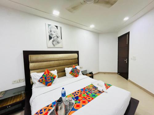 a bedroom with a large bed with white walls at Hotel Seven Malviya Nagar in New Delhi