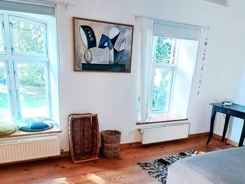 a bedroom with three windows and a bed and a table at Spacious Cottage Retreat in Sonderborg-By Traum in Sønderborg