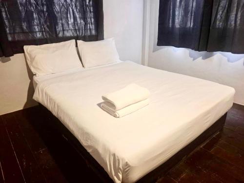 a white bed with two folded towels on it at X Mitr Inn Khaosan Road มิตร อินน์ ตรอกข้าวสาร in Bangkok