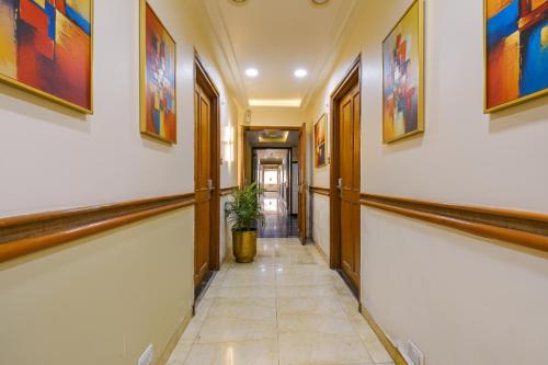 a hallway with paintings on the walls and a potted plant at FabHotel SR Wakad - Nr Mall of Millenium in Pune
