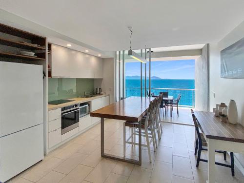 a kitchen and dining room with a view of the ocean at 1 Bright Point Apartment 4305 in Nelly Bay