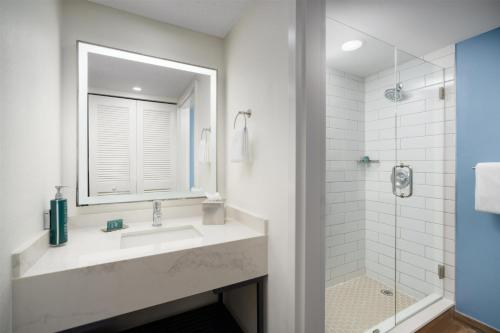 a bathroom with a sink and a mirror and a shower at DoubleTree by Hilton Grand Key Resort in Key West