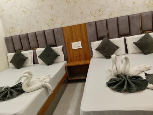 two beds in a hotel room with swans on them at Gray Stone- Two mints by walk From Golden Temple in Amritsar