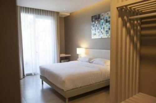 a bedroom with a white bed and a window at Double G Resort Anyer in Carita