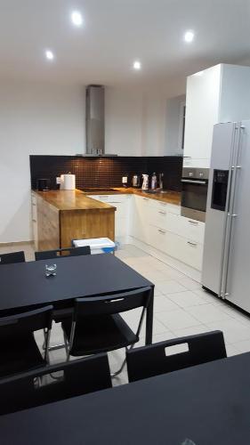 a kitchen with a black table and a refrigerator at Spa Apartamenty Lidzbark in Lidzbark