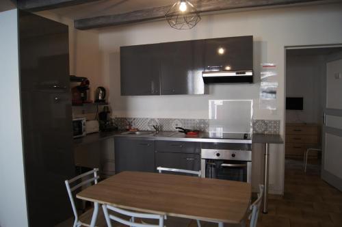 a kitchen with a table and a stove and a refrigerator at centre historique T2 RDC in La Roche-Posay