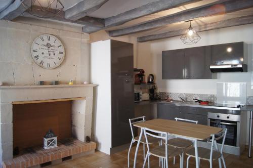 a kitchen with a table and a clock on the wall at centre historique T2 RDC in La Roche-Posay