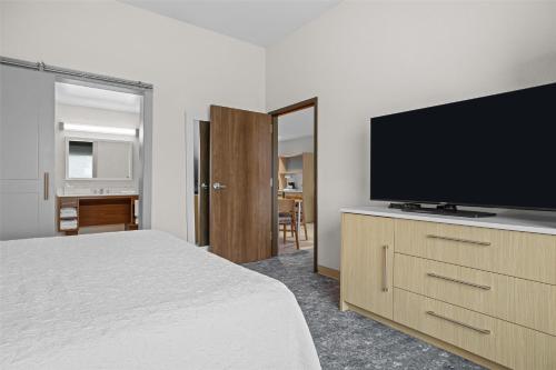 a bedroom with a bed and a flat screen tv at Home2 Suites By Hilton Pigeon Forge in Pigeon Forge