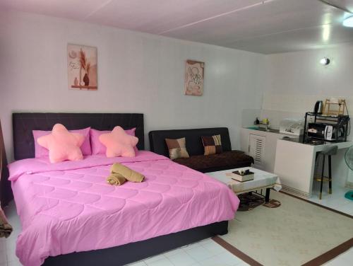 a pink bed with pink pillows in a bedroom at อิมแพ็ค popular condo c5 แม่ตังค์ in Ban Bang Phang