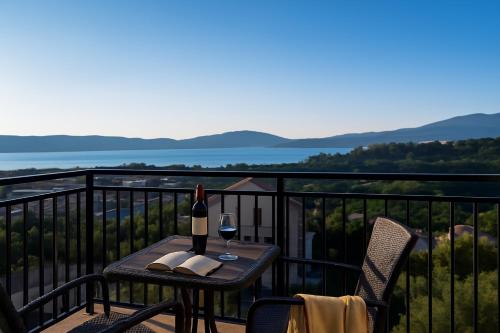 a table with a glass of wine on a balcony at Valmere Members Luxury Sea View Apartment Tivat in Tivat