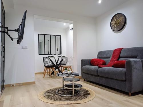 una sala de estar con un sofá y una mesa en Elégance, sobriété, T2 centre-ville, en Le Mans