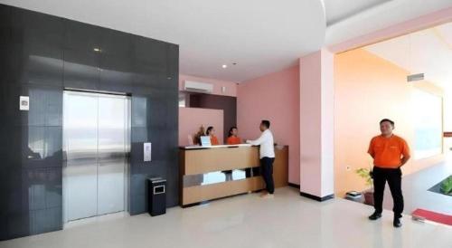 two men standing in a room with a counter at Sakura Manado in Manado