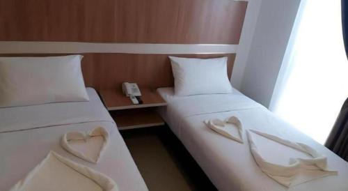 two beds with hearts on them in a room at Sakura Manado in Manado