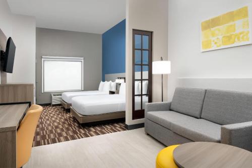 a living room with a couch and a bed at Comfort Suites Lake City in Lake City