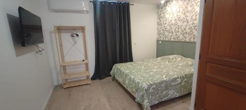 a small bedroom with a bed and a television at Cocon confort 