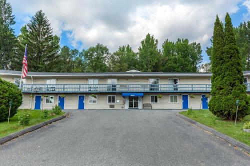 a large white building with a balcony at Econo Lodge Lee - Great Barrington in Lee