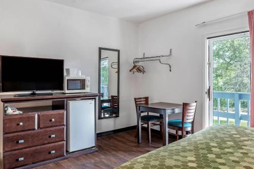 a bedroom with a desk with a television and a table at Econo Lodge Lee - Great Barrington in Lee