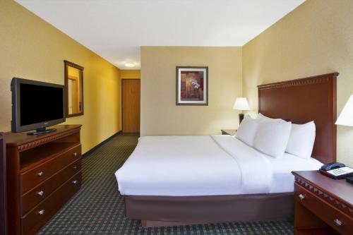 a hotel room with a bed and a flat screen tv at Quality Inn Marshall near I-69 in Marshall