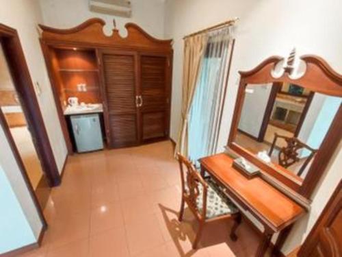 a bathroom with a wooden desk and a mirror at The Oxalis Regency Hotel in Magelang