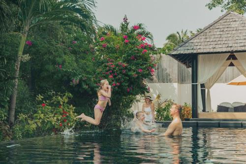 a group of children playing in a swimming pool at Sun Siyam Iru Fushi with Free Transfer in Manadhoo